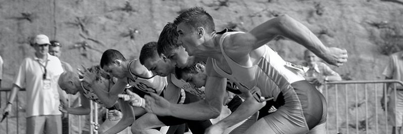 athletes-running-on-track-and-field-oval-in-grayscale-34514